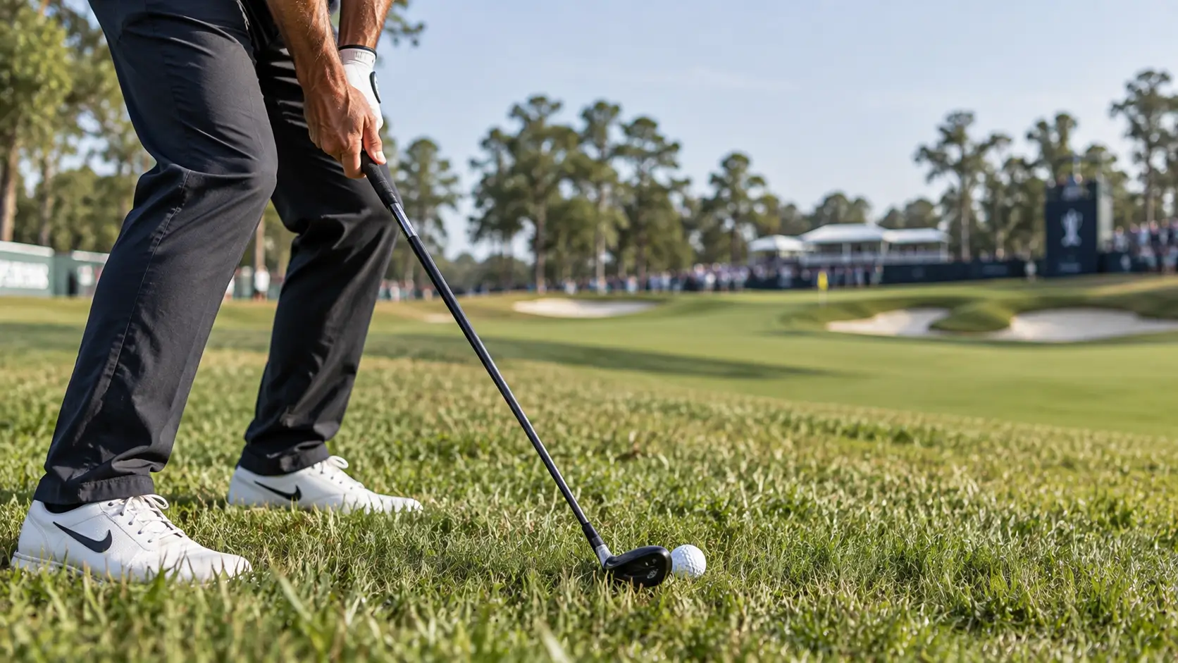 Golfer addressing the ball with a 3 hybrid out of rough grass on the course