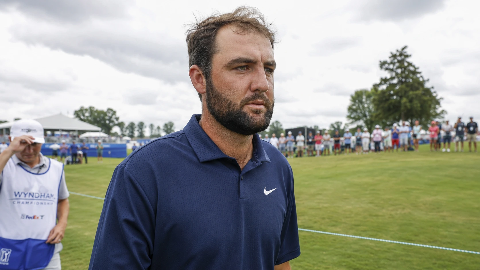 Serious close-up shot of Scottie Scheffler looking focused during an R&A major championship under gray skies